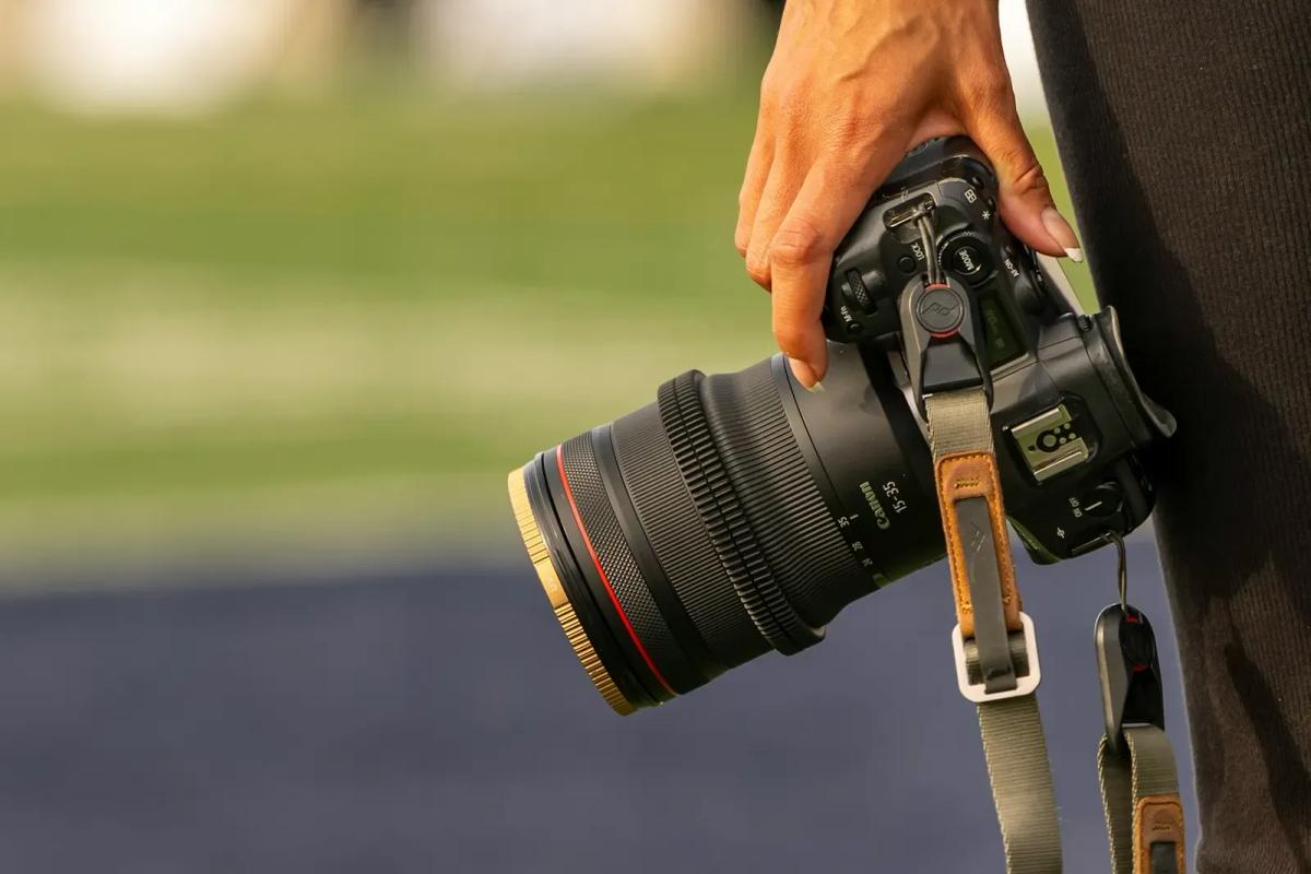 Photographe de course tenant son appareil équipé d'un téléobjectif au bord de la piste